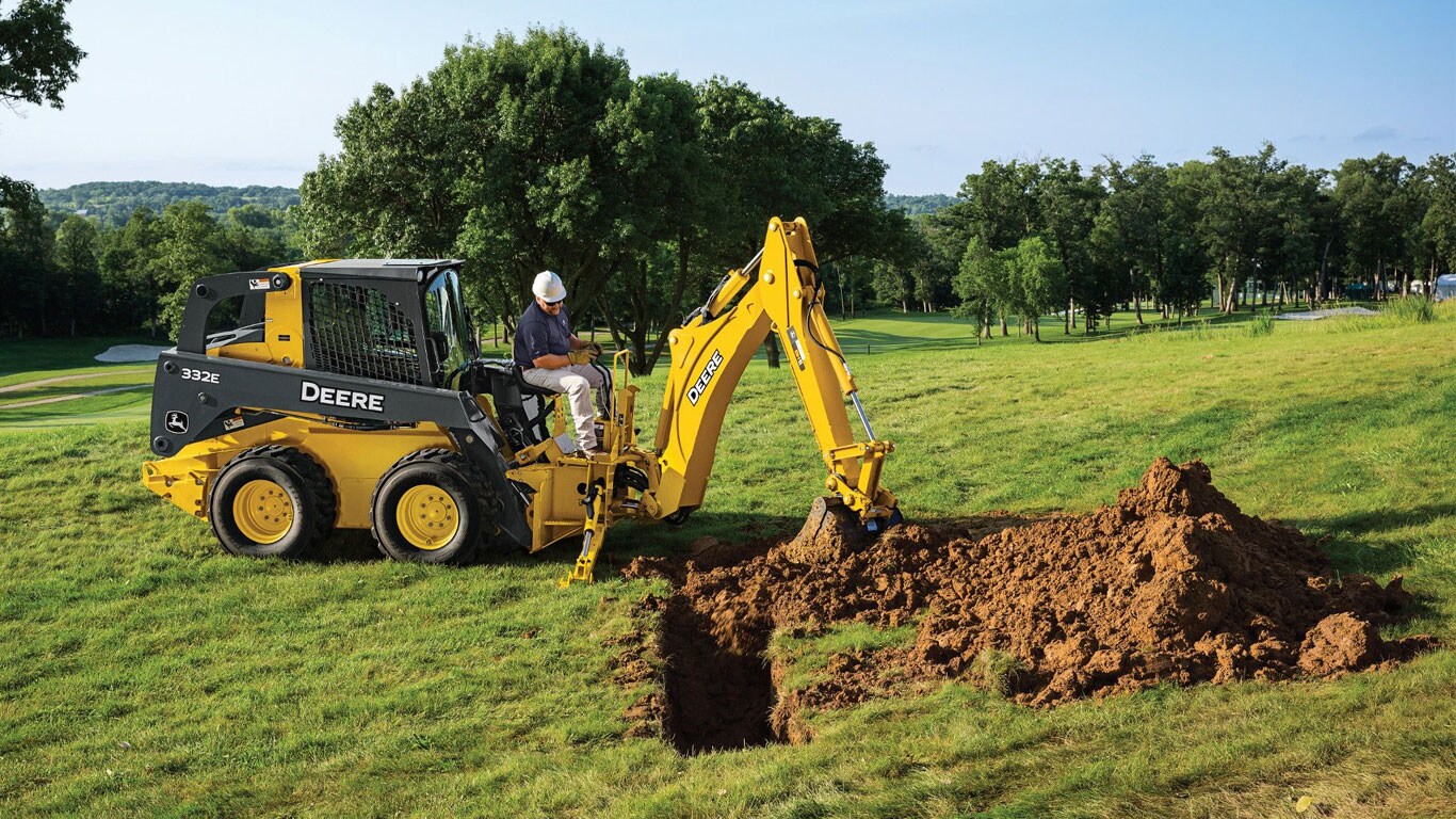 John Deere Skid Steer with Backhoe Attachment digging a hole